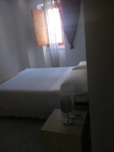 波利卡斯特罗巴森迪诺Appartamenti Centro Policastro的一间卧室设有一张大床和一个窗户。