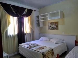 本图贡萨尔维斯唐若昂旅馆的卧室配有白色的床和窗户