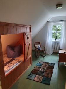 HalbemondDat moi lüttje Ostfreesen Landhuus的一间卧室配有双层床、椅子和窗户