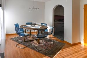 安德马特Haus Sonnboden的一间带桌子和蓝色椅子的用餐室