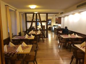 康斯坦茨Gasthaus Adler Allmannsdorf的配有桌椅的餐厅,以及坐在桌子上的人