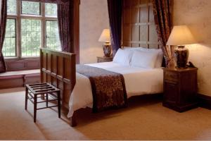 泰恩河畔纽卡斯尔Otterburn Castle的卧室配有床、椅子和窗户。