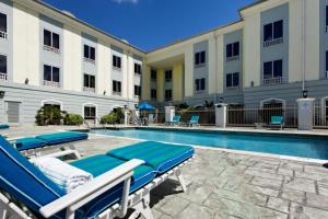 Piarco特里希迪智选假日酒店的一个带躺椅的游泳池和一间酒店