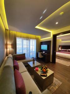 非斯Nour Plazza Hotel的带沙发、电视和床的客厅