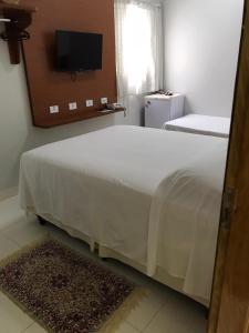 乌贝兰迪亚Hotel Itamarati的卧室配有一张大白色床和电视。
