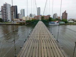 帕苏迪托雷斯Casa de praia的一座河上的桥梁,以城市为背景