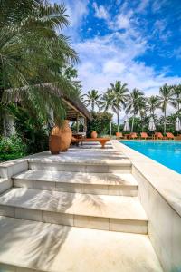 托兰克索Hotel e Resort Villas de Trancoso的一个带游泳池和棕榈树的度假村