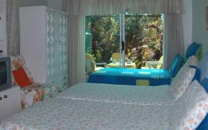 开普敦瑞秋他乡之家酒店的一间卧室设有两张床和大窗户
