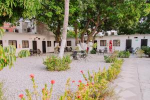 圣玛尔塔Hotel Cuchara de Palo Ayenda的庭院配有桌椅和树木