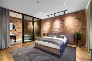 海乌姆诺克尔明斯基公寓的一间卧室设有砖墙和一张床
