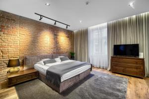 海乌姆诺克尔明斯基公寓的一间卧室设有一张大床和砖墙