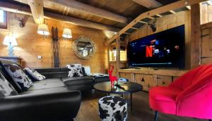 勒布罗伊斯Cosy Lodge au pied de l'Alpe D'Huez SKi et Détente Jacuzzi Piscine Sauna Bar Billard的带沙发和电视的客厅