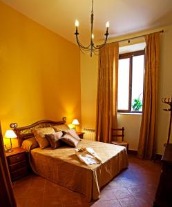 Torija埃尔撒雷洛乡村酒店的一间卧室配有一张黄色墙壁和吊灯的床。