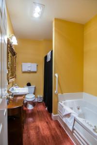 尤金The Campbell House Inn的带浴缸、卫生间和盥洗盆的浴室