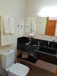 蒙特韦尔迪Robinson Cottage Monte Verde MG的浴室配有白色卫生间和盥洗盆。