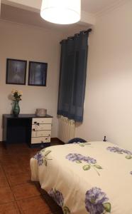 因凡特斯新镇CASA RURAL BUENA VENTURA的一间卧室,床上有紫色鲜花
