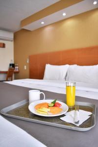 圣路易斯波托西易波萨达套房酒店的盘子上放着一盘食物和一杯橙汁