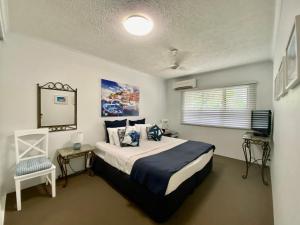 凯恩斯凯恩斯海滩公寓式酒店的一间卧室配有一张床和一台电视