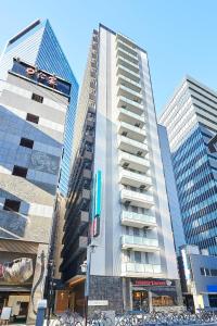 名古屋Sotetsu Fresa Inn Nagoya Sakuradoriguchi的一座高大的建筑,前面有自行车停放