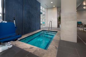 ArdenHoliday Inn & Suites Arden - Asheville Airport, an IHG Hotel的浴室设有游泳池、椅子和浴缸