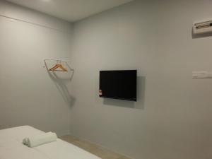 Simpang RenggamL Hotel的白色的房间,墙上配有电视