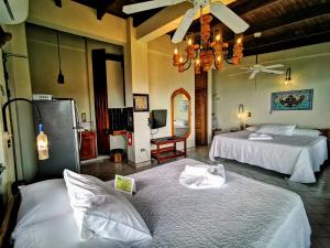 曼努埃尔安东尼奥绿色海岸酒店的酒店客房设有两张床和吊灯。