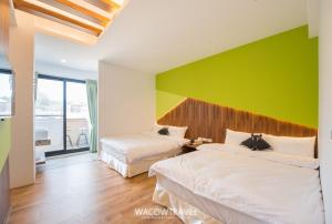 小琉球岛小海子旅宿的一间卧室设有两张床和绿色的墙壁
