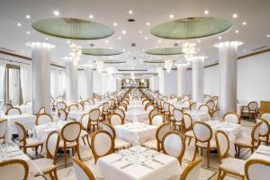 吉奥塔略Mitsis Rodos Maris的宴会厅配有白色的桌椅和吊灯