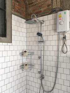 南府PX122 DBEST HOTEL的浴室铺有白色瓷砖,设有淋浴。
