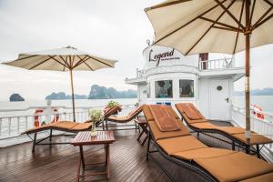 下龙湾传奇下龙私人邮轮酒店 - 哈亚巡游管理局的船上的甲板上配有椅子和遮阳伞