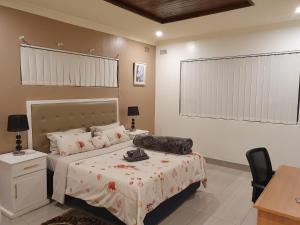 布拉瓦约Grey Oak Holiday House的一间卧室配有一张床、一张桌子和一把椅子