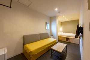 东京plat hostel keikyu minowa forest的客厅配有沙发和1张床