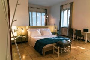 加拉瑞特Palazzo Pasta Malpensa的酒店客房带一张床、一张桌子和椅子
