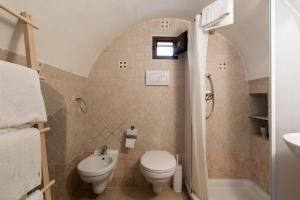 奥斯图尼White House Flats & Studios的浴室配有卫生间、盥洗盆和淋浴。
