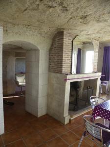 NazellesLes Hauts de Nazelles的客房设有壁炉、桌子和椅子。