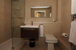 滨海绍森德大楼公寓的一间带水槽、卫生间和镜子的浴室