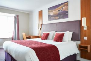 北沃尔瑟姆Wheatsheaf by Chef & Brewer Collection的酒店客房配有一张带红色枕头的大床
