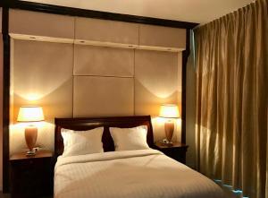 海牙The City Palace - R.Q.C.的一间卧室配有一张带两盏灯的大型白色床。