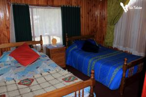 达卡卫Hospedaje Isla Talcan的一间卧室设有两张单人床和一个窗户。