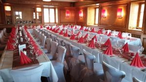 HerrischriedGasthaus zum Ochsen的大房间设有桌椅和红色餐巾