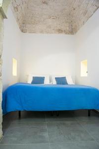 奥斯图尼Elaion Home的白色客房内一张大蓝色的床