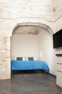 奥斯图尼Elaion Home的一间卧室,在石墙内配有一张蓝色的床