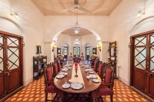 马泰兰SaffronStays Parsi Manor, Matheran的大型用餐室配有长桌和椅子