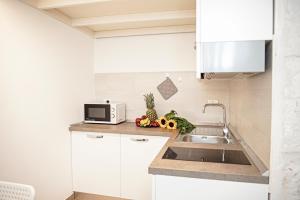 奥斯图尼Liberty Bell的厨房配有白色橱柜和水槽