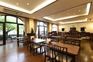 高岛市Reposer makino的餐厅设有木桌、椅子和窗户。