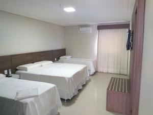 Belo JardimHotel Asa Branca的酒店客房设有两张床和电视。