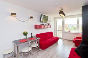 格但斯克斯洛内克奇波鲁迪尼公寓的客厅配有红色的沙发和桌子