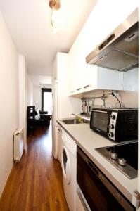 马德里Charming Madrid Urgel的厨房配有水槽和炉灶 顶部烤箱