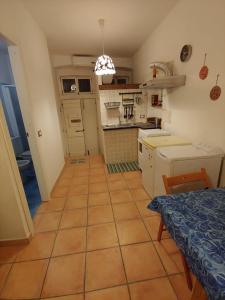 马蒂纳塔Casa Vacanze Gargano Mattinata的一间铺有瓷砖地板并配有桌子的小厨房