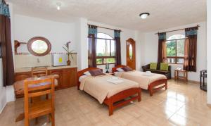 阿约拉港Hotel Twin Galápagos的一间卧室配有两张床、一张桌子和一把椅子